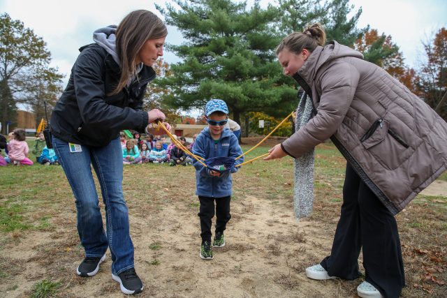 child loading pumpkin into launcher