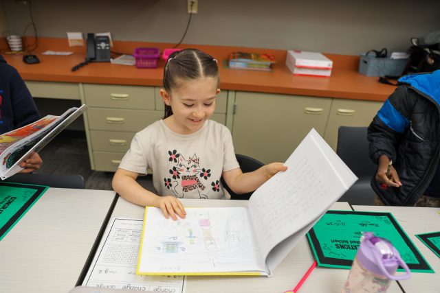 Second grader Looks at her book.