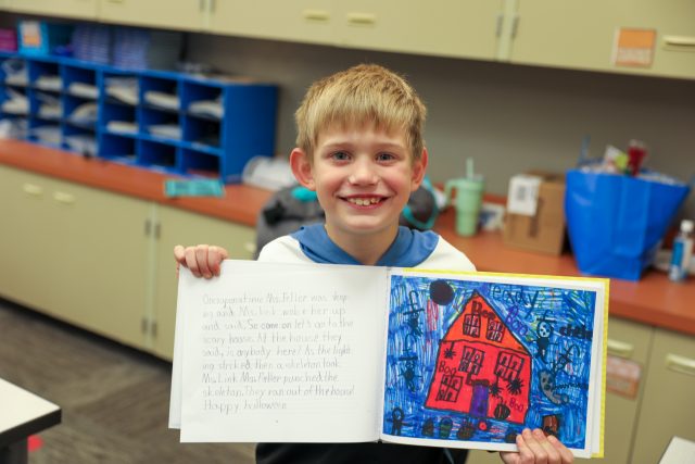 Second grader shows off book.