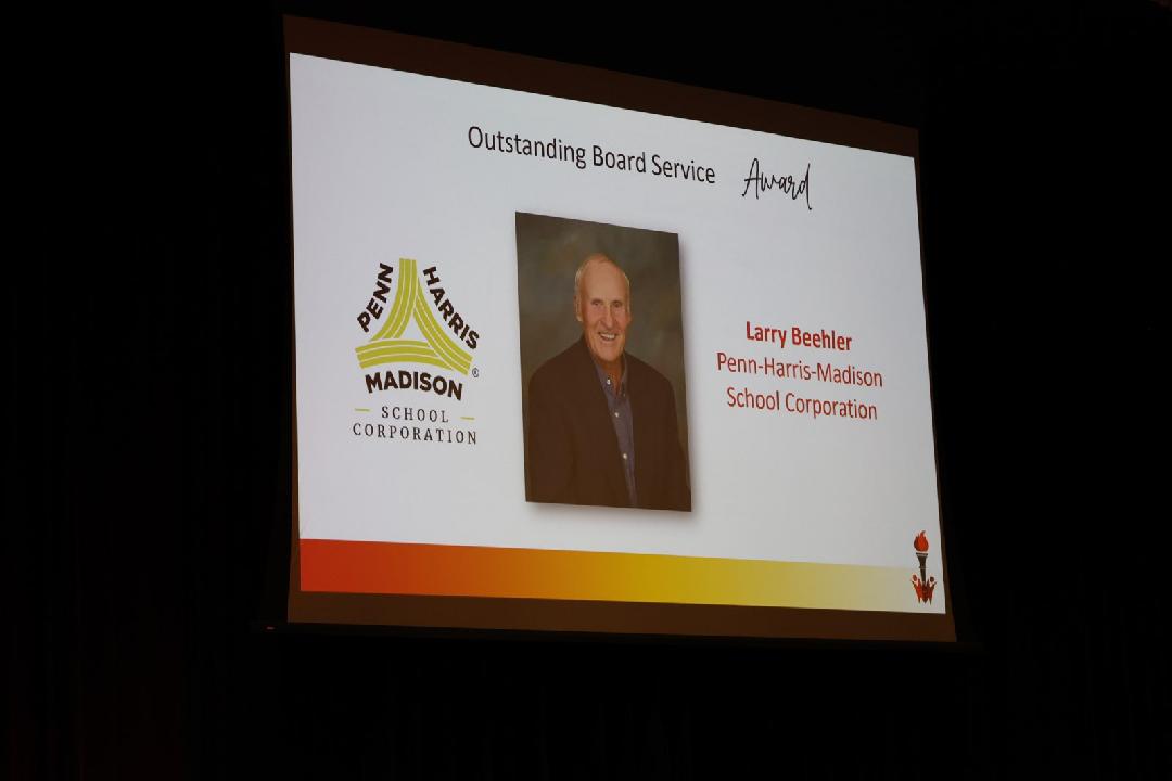 A presentation slide with a photo of a man and text that reads "Quality Service Award" and "Larry Wohlwend, Madison School